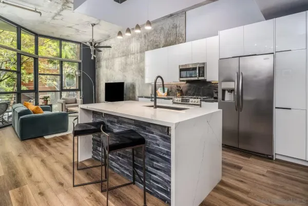 a kitchen with stainless steel appliances a table chairs and a refrigerator