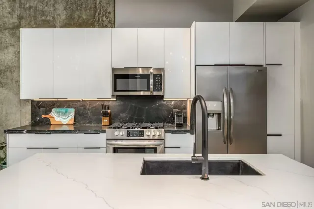 a kitchen with stainless steel appliances granite countertop a refrigerator sink and stove