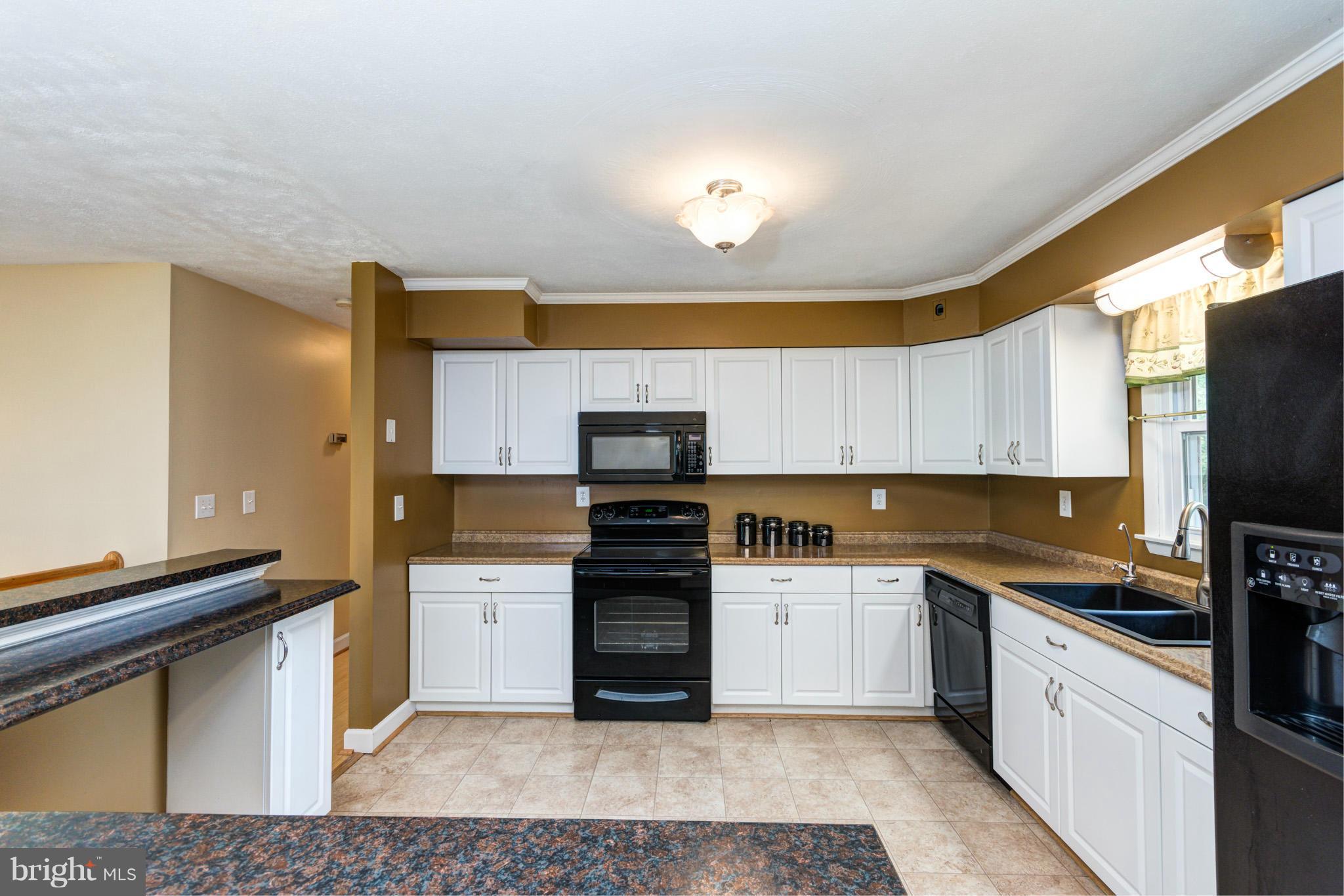 730 Rosewood Road Severn, MD 21144 - Photo 7 of 30 a kitchen with stainless steel appliances granite countertop a stove a sink and a refrigerator
