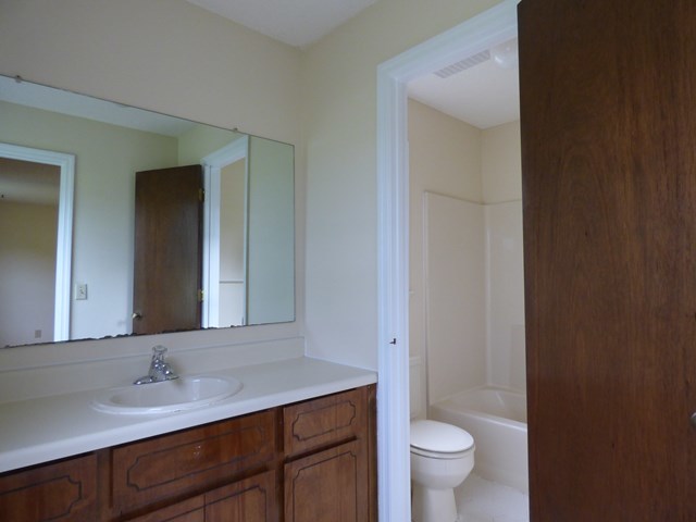 4628 Jones Road Macon, GA 31216 - Photo 15 of 25 a bathroom with a granite countertop sink a toilet and a mirror