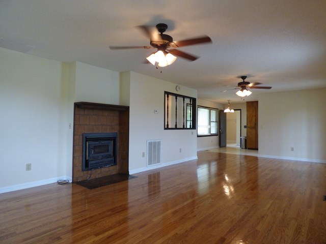 4628 Jones Road Macon, GA 31216 - Photo 5 of 25 a view of an empty room with wooden floor and a ceiling fan