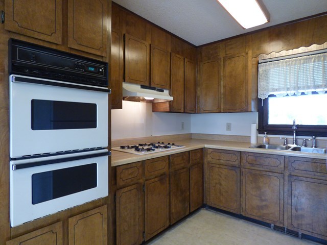 4628 Jones Road Macon, GA 31216 - Photo 9 of 25 a kitchen with stainless steel appliances granite countertop wooden cabinets and a stove top oven
