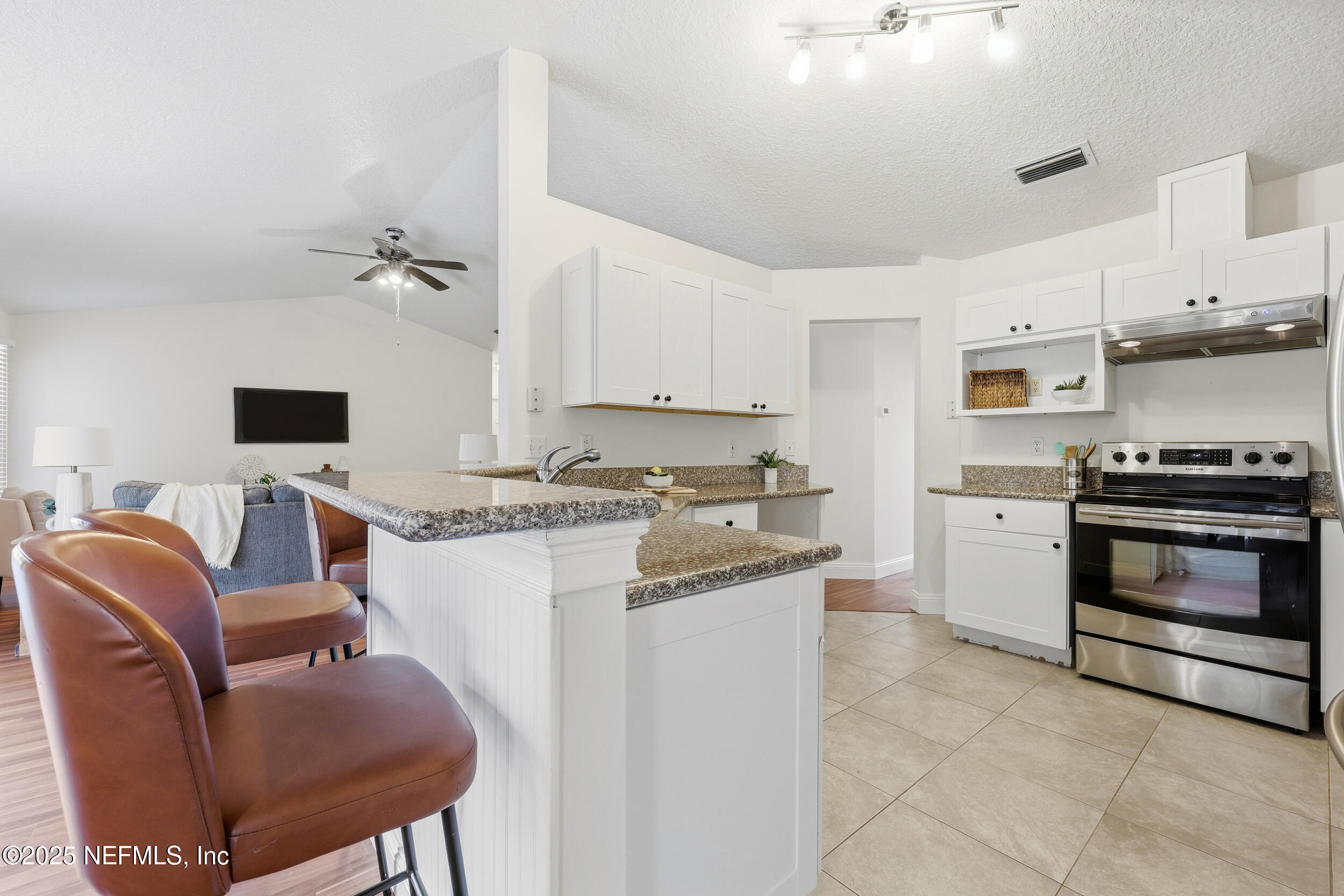 1626 Sandy Hollow Loop Middleburg, FL 32068 - Photo 6 of 40 a kitchen with stainless steel appliances granite countertop a stove top oven a sink dishwasher and white cabinets with wooden floor