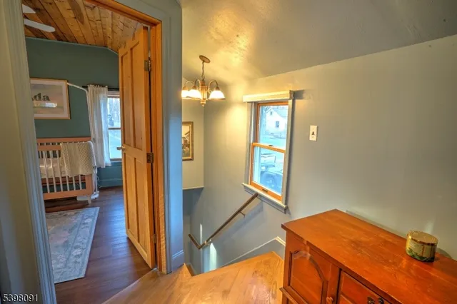 a view of a hallway with wooden floor and furniture