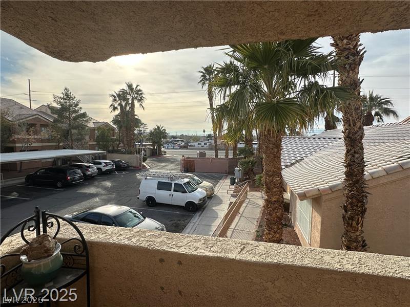 1830 North Pecos Road, Unit 230 Las Vegas, NV 89115 - Photo 16 of 16 A top-floor view reveals a community parking area bordered by thriving palm trees and low-rise residential structures.