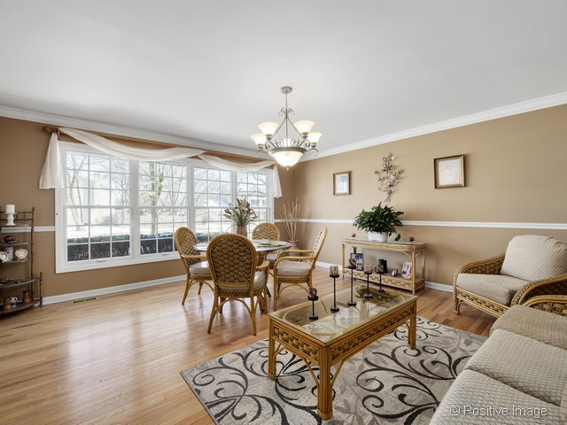 2S184 Sheffield Road Glen Ellyn, IL 60137 - Photo 2 of 25 a living room with furniture a chandelier and a large window