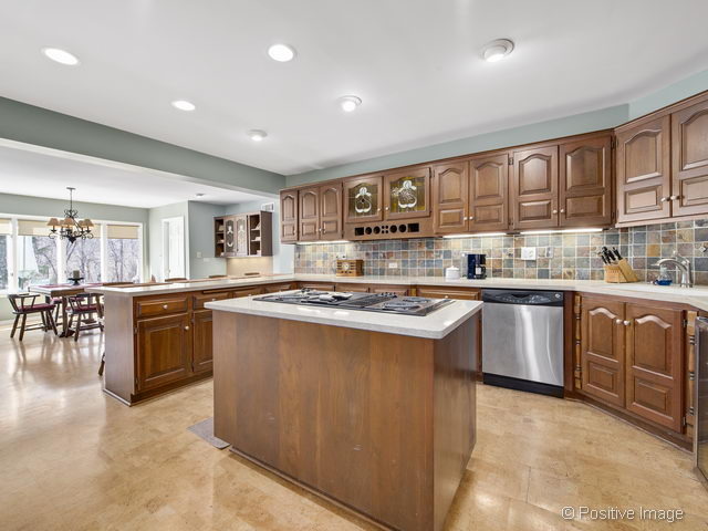 2S184 Sheffield Road Glen Ellyn, IL 60137 - Photo 11 of 25 a kitchen with kitchen island granite countertop a stove top oven a sink a dining table and chairs