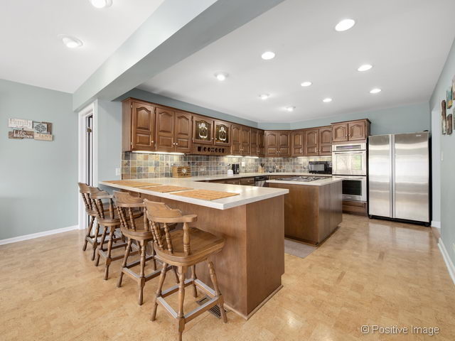 2S184 Sheffield Road Glen Ellyn, IL 60137 - Photo 10 of 25 a kitchen with stainless steel appliances kitchen island granite countertop a sink and cabinets