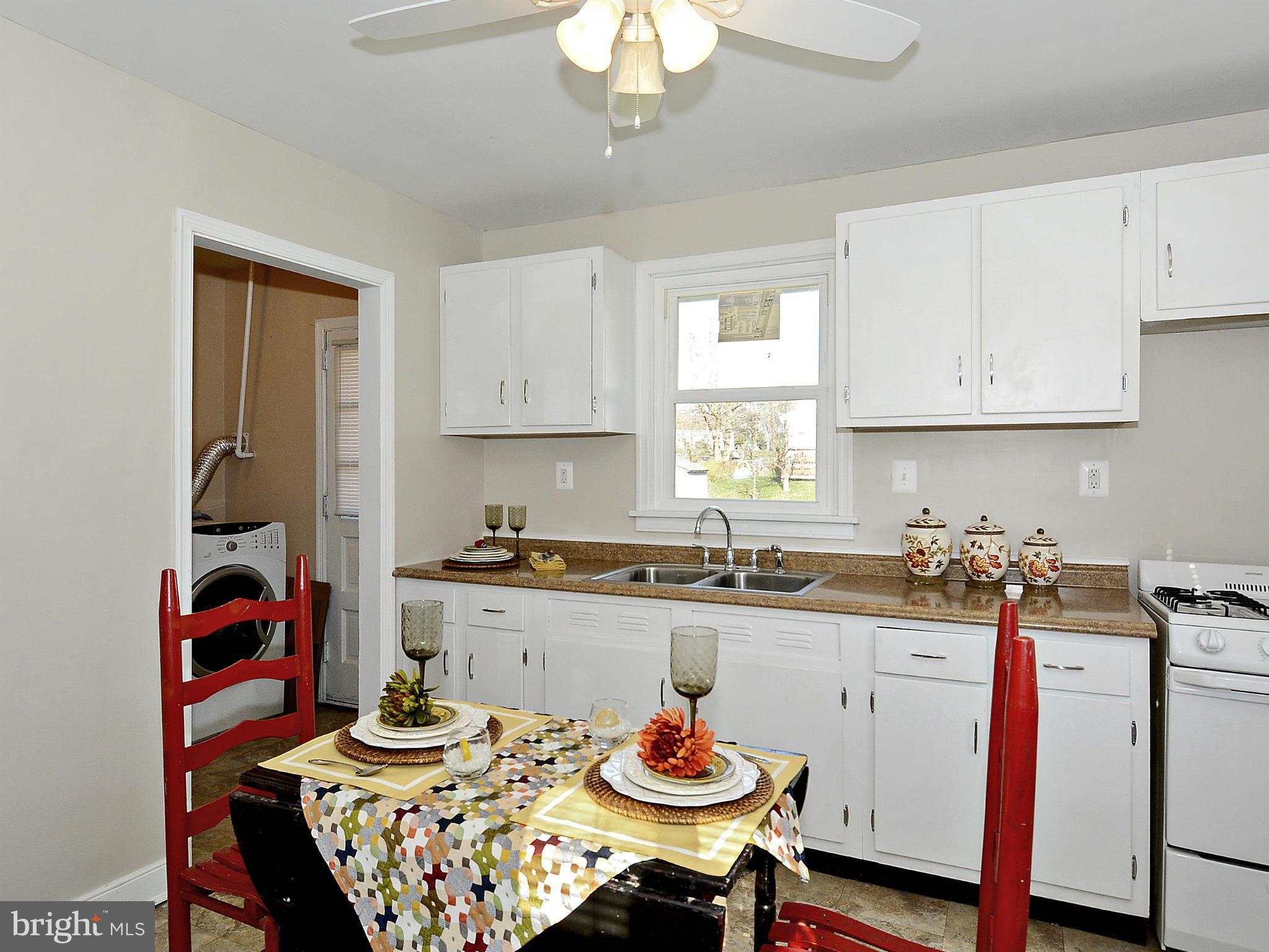 2721 Randolph Road Silver Spring, MD 20902 - Photo 7 of 25 a kitchen with a dining table and cabinets stove top oven
