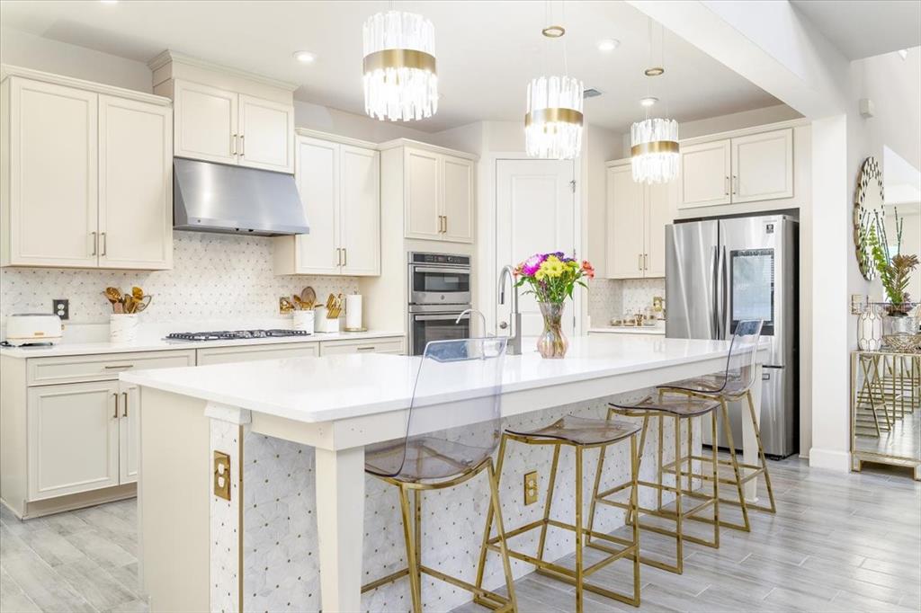 1296 Waterview Ridge Circle Apopka, FL 32703 - Photo 22 of 60 a kitchen with stainless steel appliances kitchen island granite countertop a table chairs in it and wooden floors