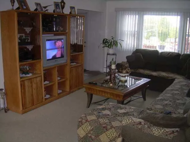 a living room with furniture a window and a flat screen tv