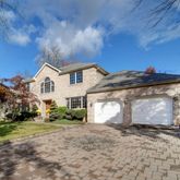 a view of a white house with a yard and plants