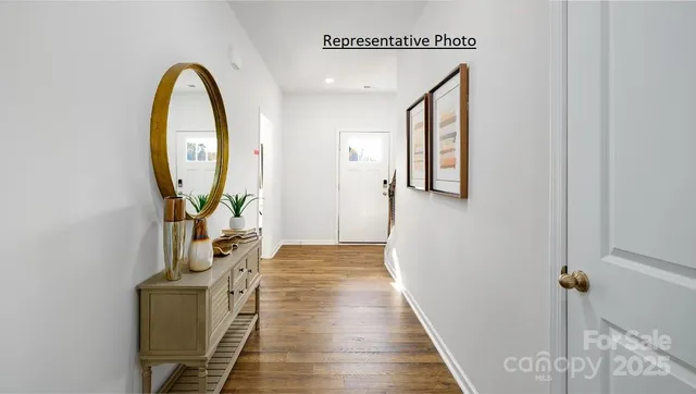 a view of a hallway with wooden floor and entryway
