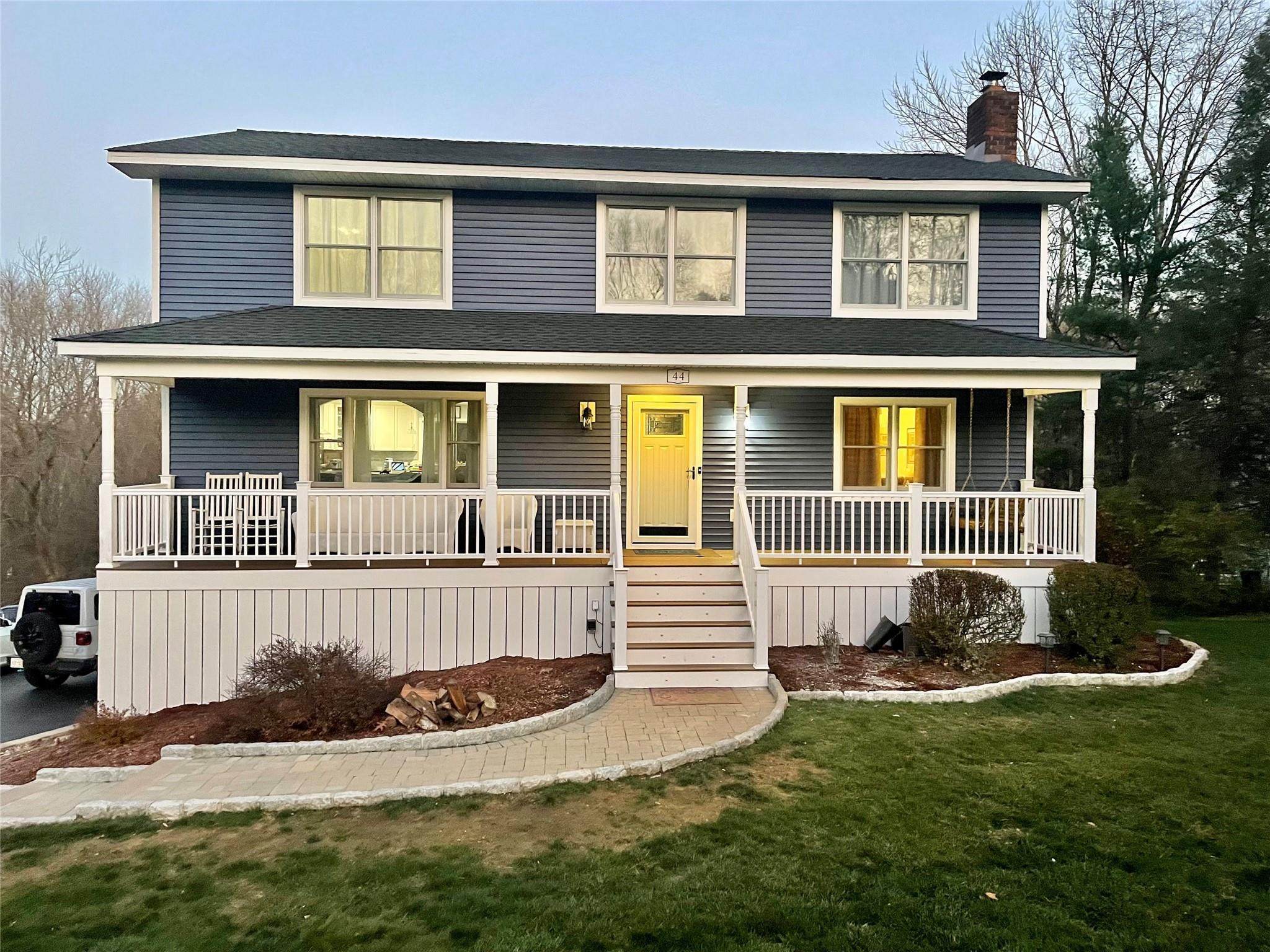 View of front facade featuring a front yard and a porch