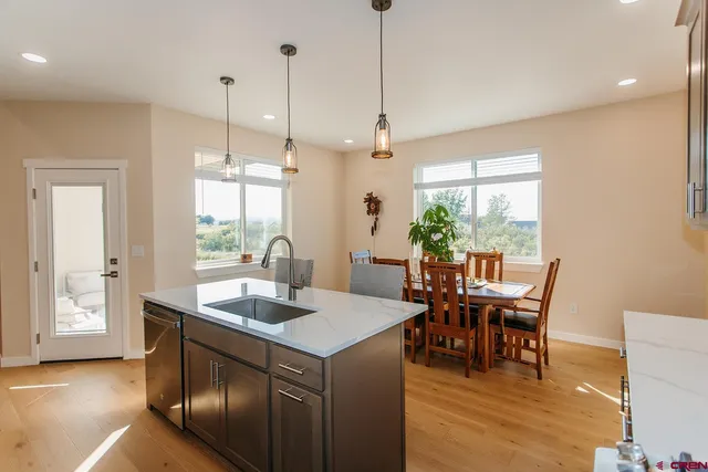 a view of a dining room and livingroom with furniture wooden floor a chandelier
