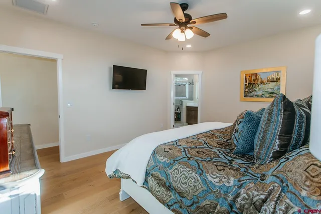 a bedroom with a bed a couch and a flat screen tv