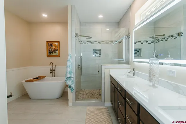 a spacious bathroom with a double vanity sink mirror and shower