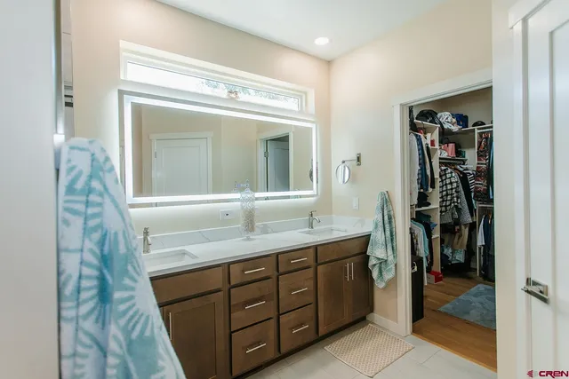 a bathroom with a granite countertop sink a mirror and a shower