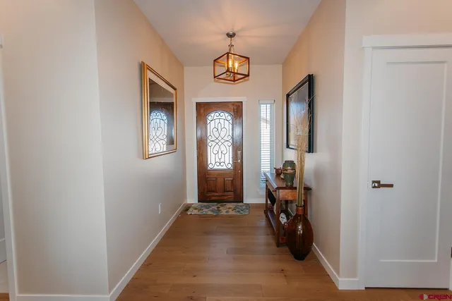 a view of a hallway with wooden floor and a livingroom