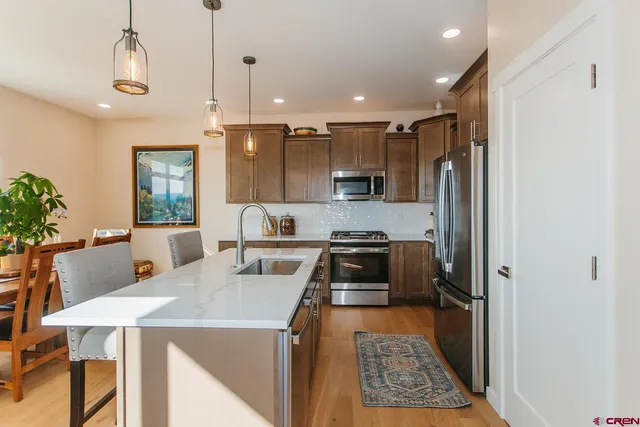 a kitchen with a stove a refrigerator and a dining table