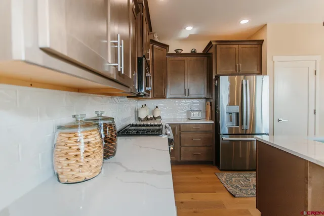 a kitchen with stainless steel appliances granite countertop a refrigerator and a sink