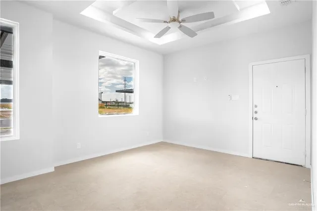 an empty room with windows and fan