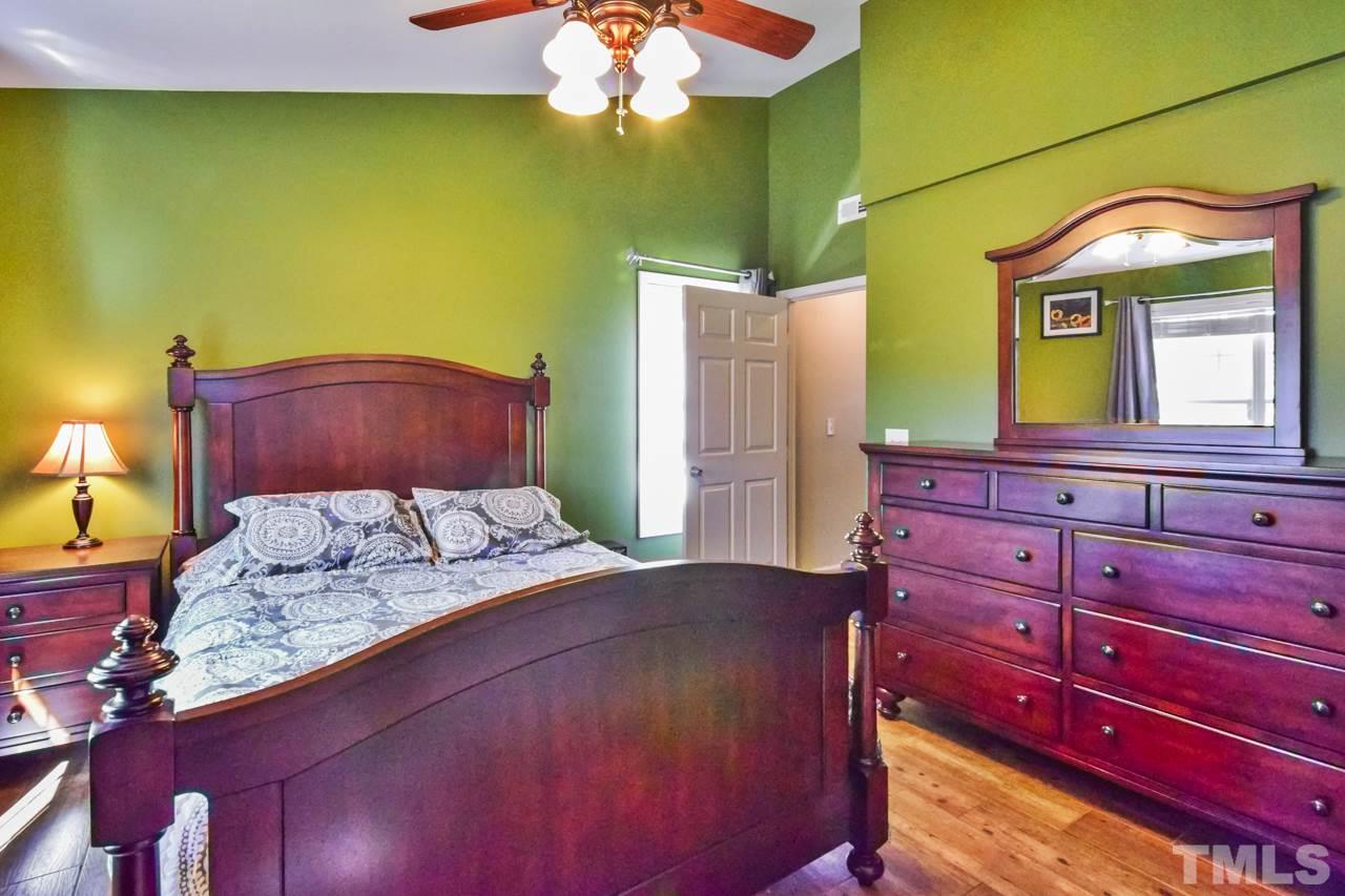 702 Method Road Raleigh, NC 27607 - Photo 15 of 25 a bedroom with a bed and a dresser with mirror