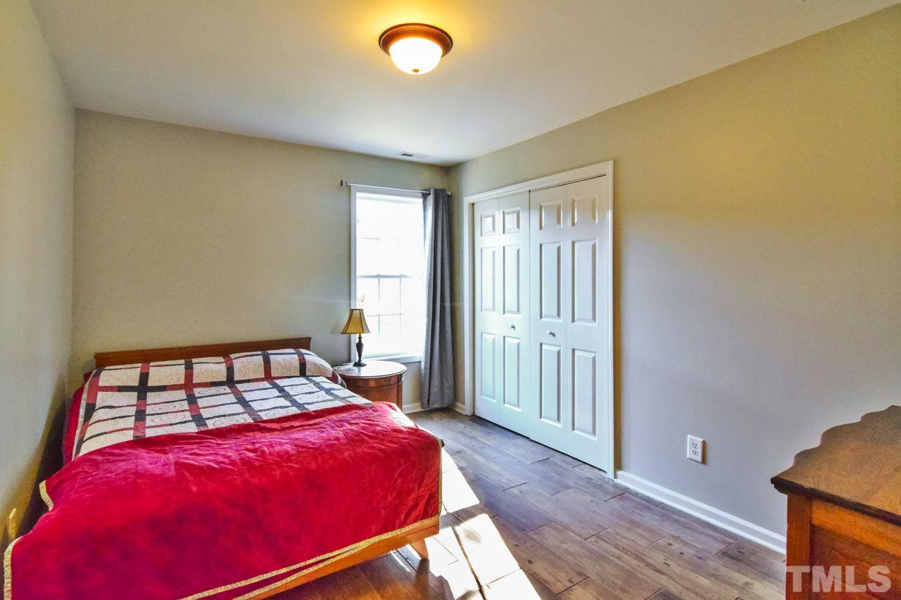 702 Method Road Raleigh, NC 27607 - Photo 19 of 25 a bedroom with a bed and wooden floor