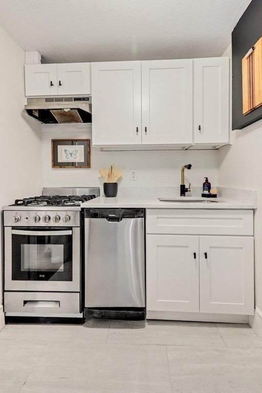 2 Goodwin Place, Unit 3 Boston, MA 02114 - Photo 10 of 28 a kitchen with white cabinets and appliances