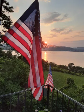 a view of a lake with a yard and potted plants
