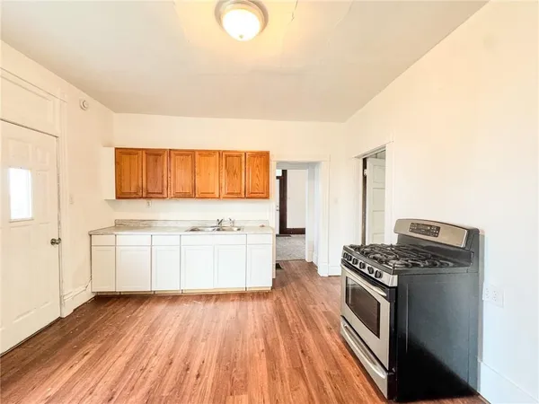 a kitchen with granite countertop a stove and a wooden floors