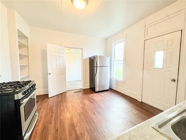 a view of a kitchen with wooden floor and electronic appliances