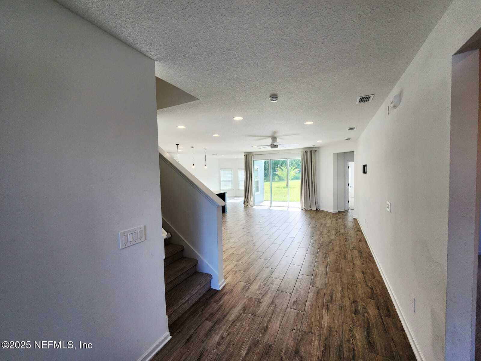 577 Archstone Way St. Augustine, FL 32092 - Photo 5 of 45 a view of hallway with wooden floor and staircase