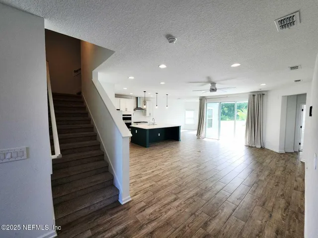 a view of a kitchen with a sink wooden floor and a living room