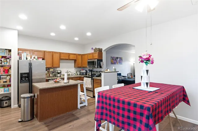 a kitchen with stainless steel appliances kitchen island granite countertop a dining table and chairs