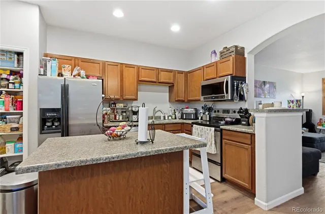 a kitchen with stainless steel appliances granite countertop a sink stove and refrigerator
