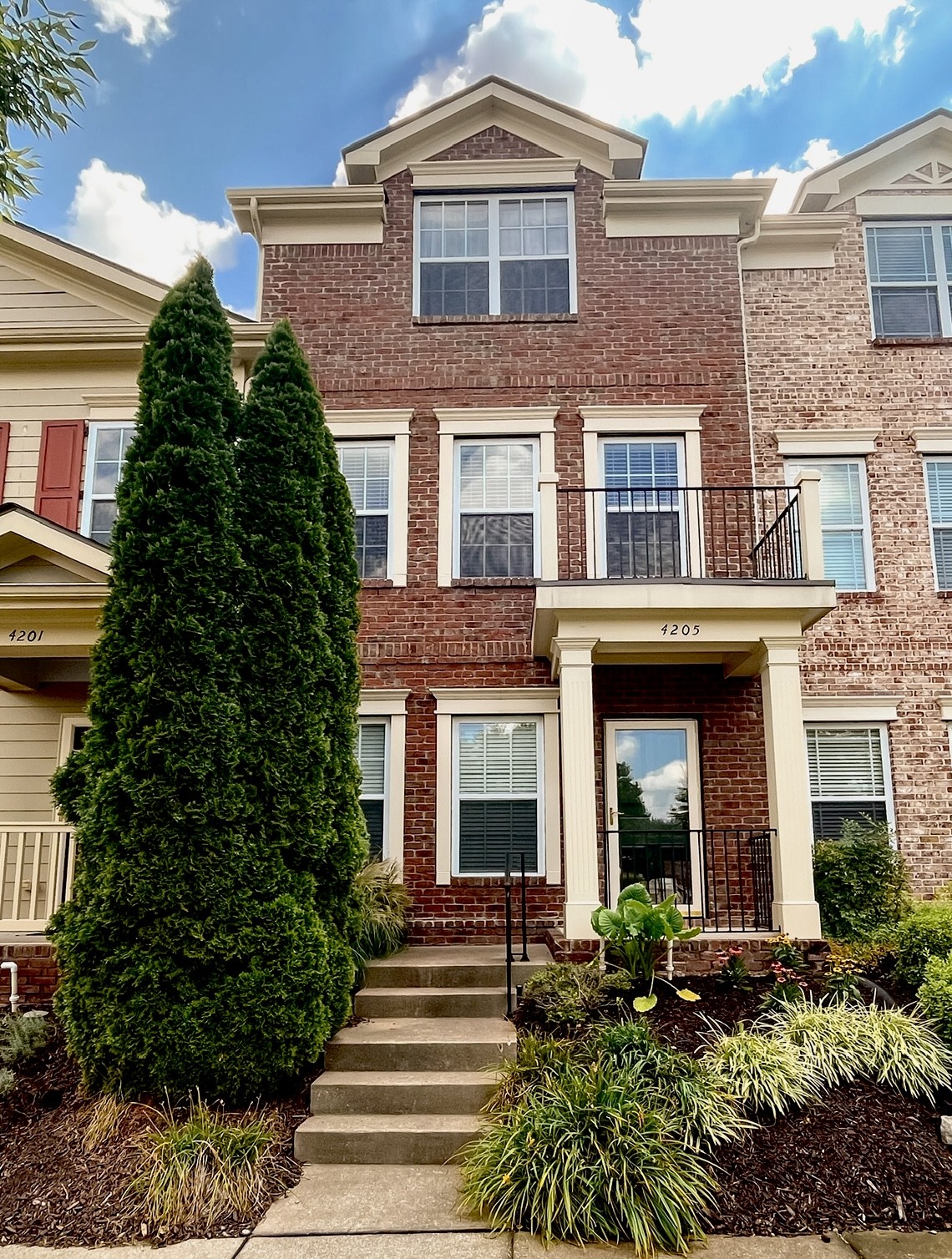 front view of a brick house with a yard
