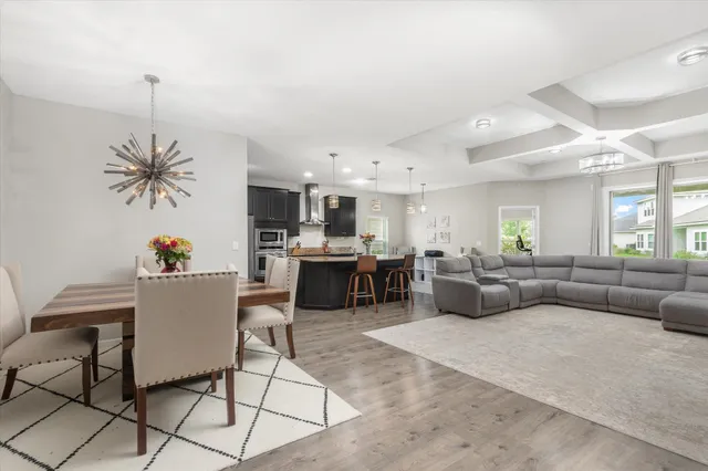a living room with furniture kitchen view and a chandelier