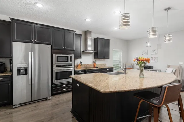 a kitchen with granite countertop a refrigerator stove and microwave