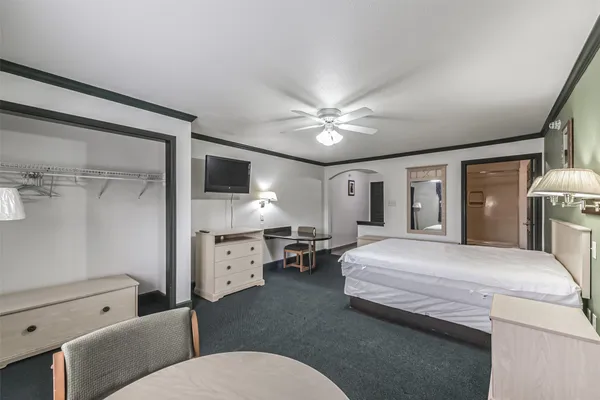 a spacious bedroom with a bed and ceiling fan