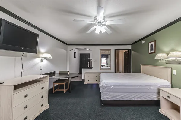 a spacious bedroom with a bed and a chandelier