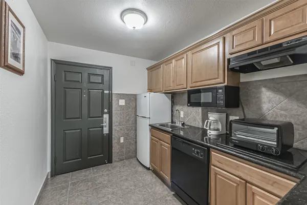 a kitchen with stainless steel appliances granite countertop a refrigerator a stove and a sink