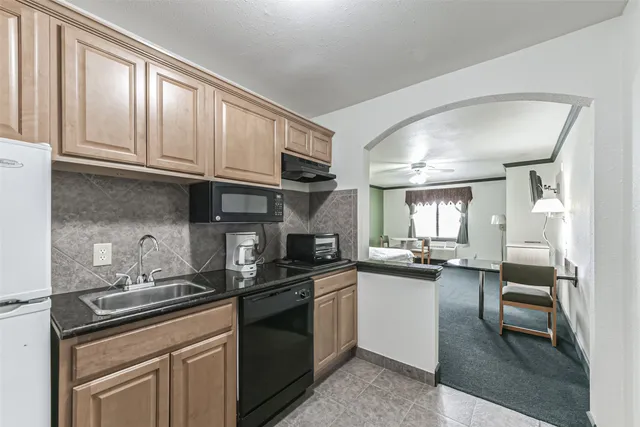 a kitchen with granite countertop a sink stove and cabinets