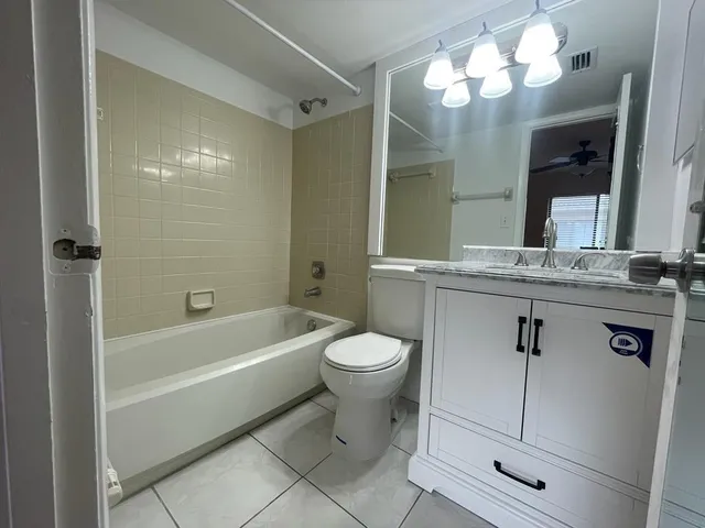 a bathroom with a sink a toilet a mirror and shower