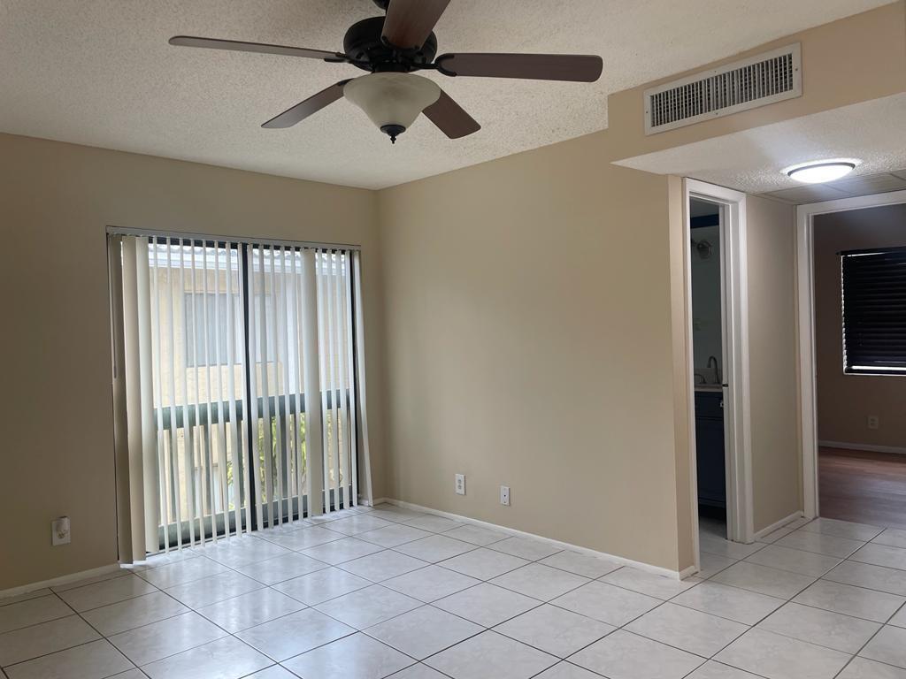 2621 Riverside Drive, Unit 6 Coral Springs, FL 33065 - Photo 3 of 20 an empty room with windows and a chandelier fan