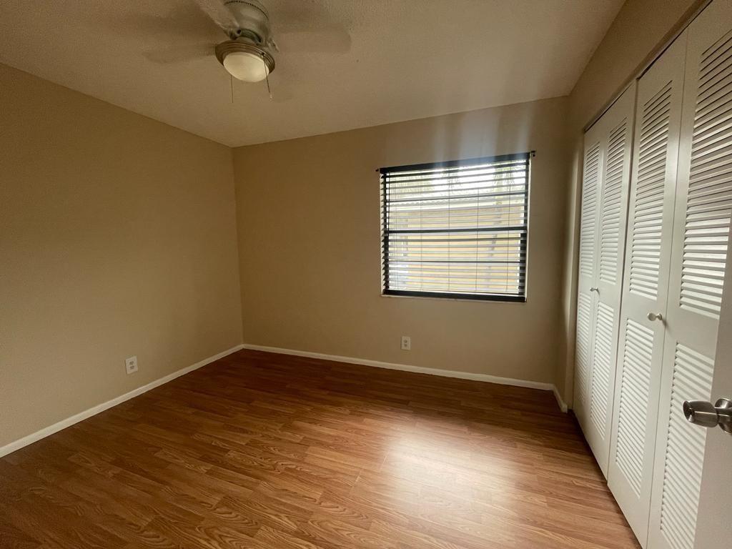 2621 Riverside Drive, Unit 6 Coral Springs, FL 33065 - Photo 8 of 20 a view of an empty room with wooden floor and a window