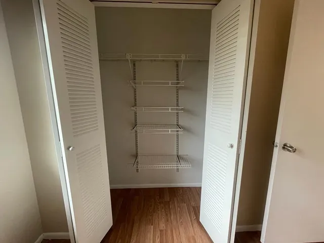 a view of walk in closet with wooden floor