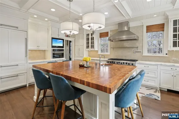 a kitchen with granite countertop a table chairs stove and cabinets