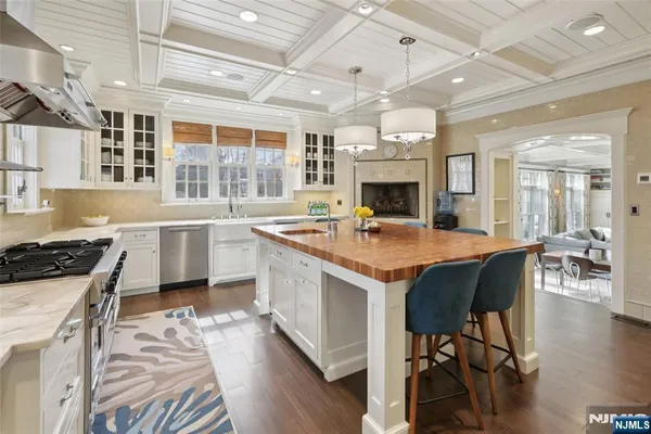 a kitchen with a stove a chandelier and wooden floor