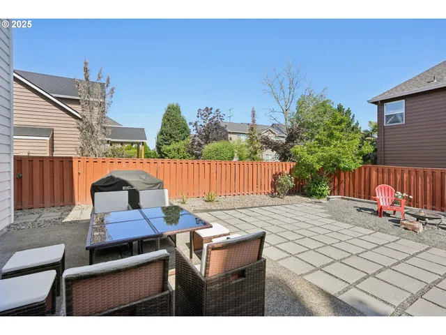 a backyard of a house with table and chairs